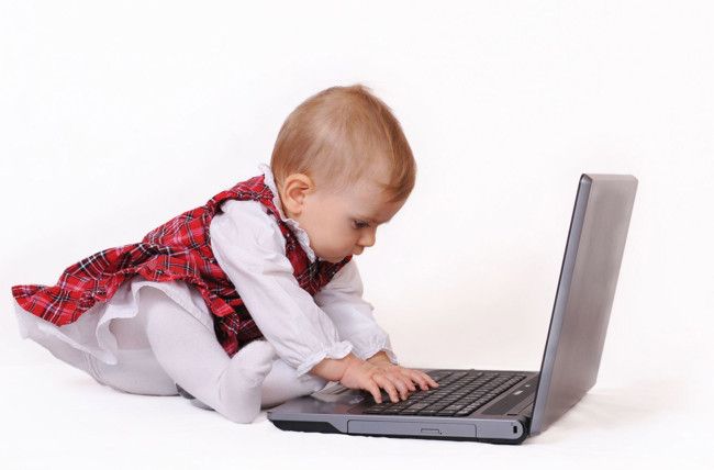 Bebé superdotado escribiendo en ordenador portatil