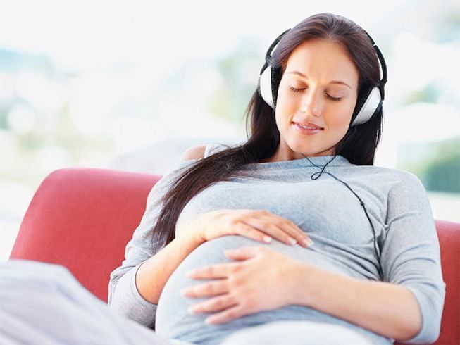 Embarazada escuchando música con auriculares