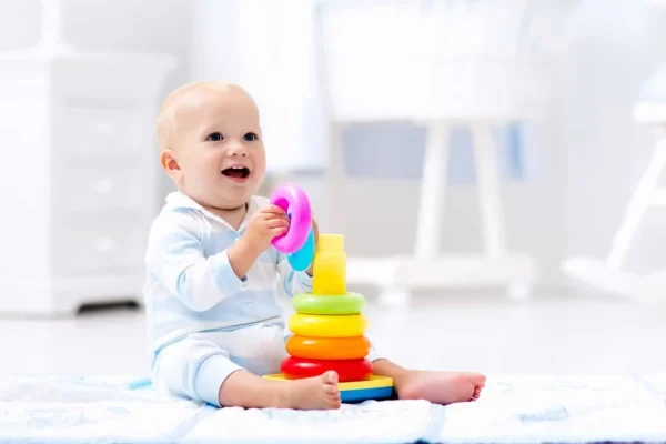 Bebé sonriendo y divirtiéndose jugando con figuras encajables